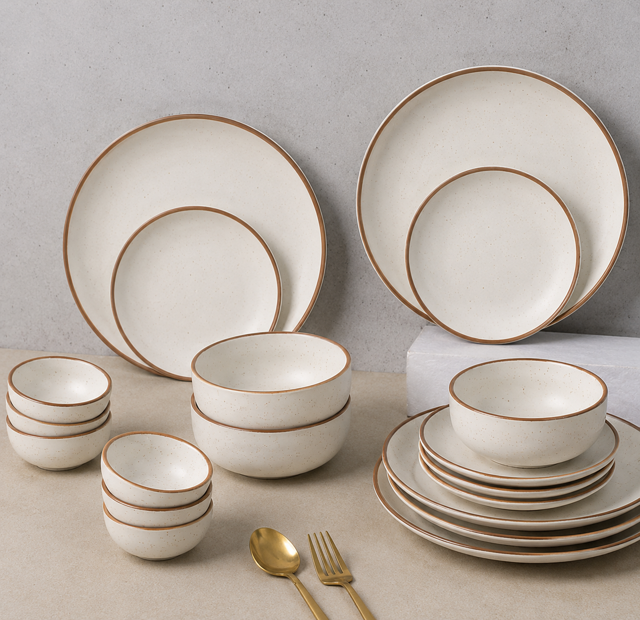 Clayzio Speckled Rim dinner set styled on a stone surface